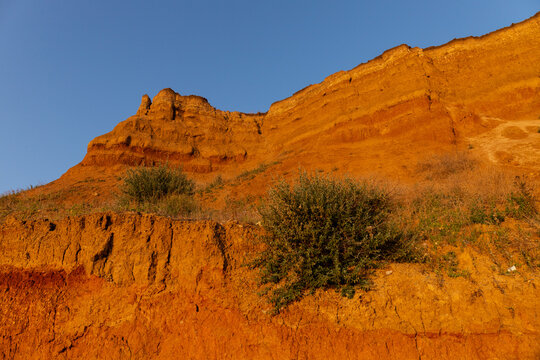 Geology. Desert landscape. Panorama view of the sandstone formation, the rocky cliffs, sand. Background or texture of sandy cliff on the coast, orange limestone