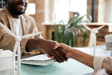 Close-up of African businessman greeting his colleague at the table during business meeting at office
