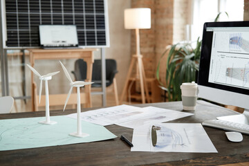 Image of workplace of architect with computer monitor blueprints and design models at office
