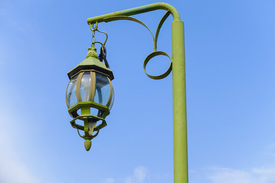 green vintage lamp and lamppost under blue sky, old retro lantern on garden street at park in asia-thailand for outdoor light