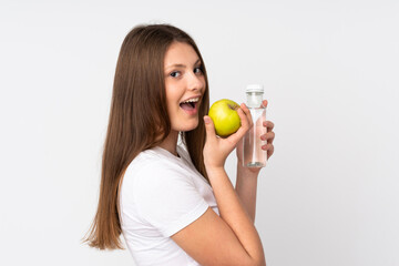 Teenager caucasian girl isolated on white background with an apple and with a bottle of water