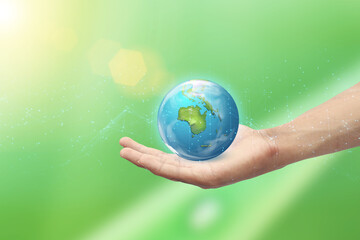 Hand holding Earth ball on green nature bokeh background. Safe world concept