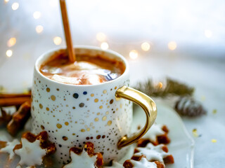 Christmas hot drink in a cup of chocolate with cinnamon and marshmallows on a white plate with star...