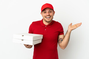pizza delivery man with work uniform picking up pizza boxes over isolated  white wall with shocked facial expression