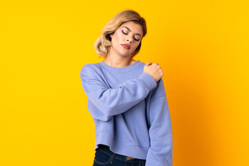 Young Russian woman isolated on yellow background suffering from pain in shoulder for having made an effort