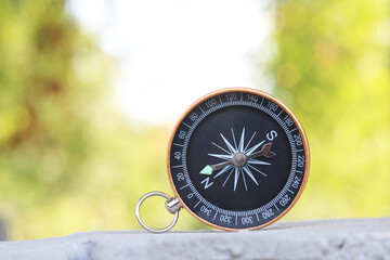 Fototapeta na wymiar round compass on gray concrete background as symbol of tourism with compass, travel with compass and outdoor activities with compass