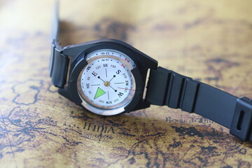 Classic round compass on background of old vintage map of world as symbol of tourism with compass, travel with compass and outdoor activities with compass