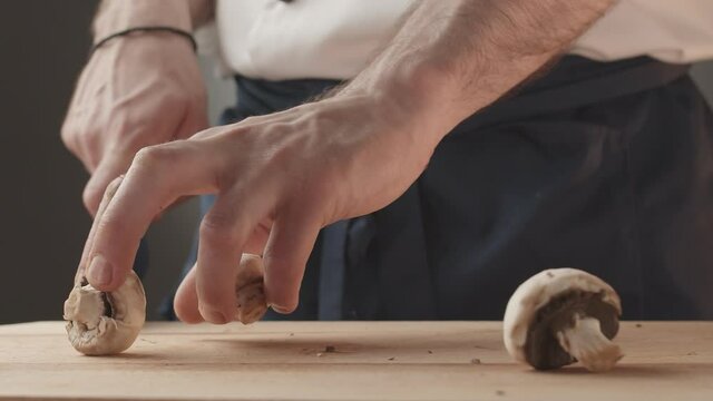  the mushrooms fall on a wooden board in the kitchen the cook prepares the food
