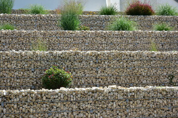 Geneigtes Wohngrundstück, neu terrassiert mit Stahlgitter-Gabionen mit Natursteinfüllung und...