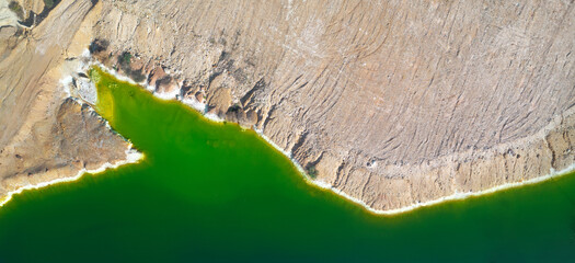 Shore of toxic green lake in abandoned open pit copper mine. its color derives from high levels of...