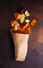 Succulent vegetable chips scattered from a kraft bag