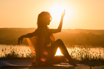 Beautiful girl silhouette in warm sunrise light