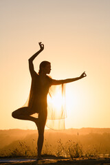 Female silhouette in yoga tree balance pose and mudra hands triange, dancing , fitness training...