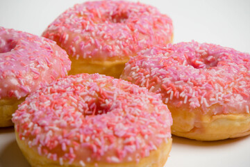 Four Iced Ring Donuts On A White Background