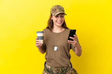 Military caucasian woman with dog tag isolated on yellow background holding coffee to take away and...