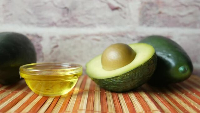 oil and slice of avocado on wooden table 