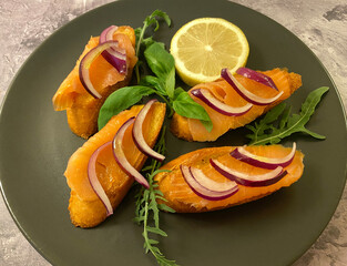 Crostini al salmone affumicato. Also known as crostini with smoked salmon, olive oil, red onions, basil, rocket and lemon.