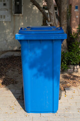 Large blue wheelie dustbin in the community area.