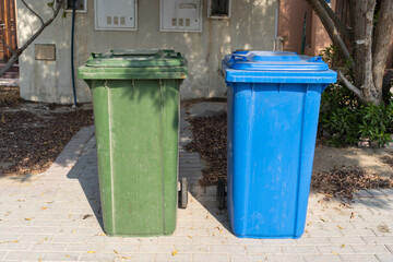 Large blue and green wheelie dustbin in the community area.