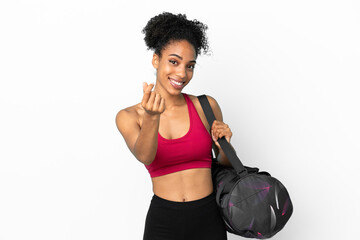 Fototapeta na wymiar Young sport african american woman with sport bag isolated on blue background making money gesture