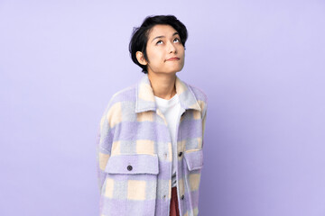 Young Vietnamese woman with short hair over isolated background and looking up