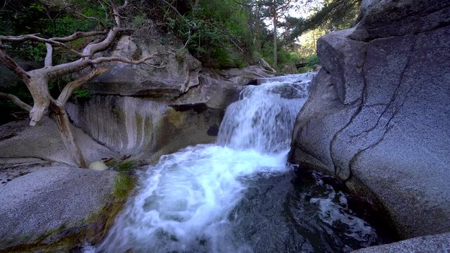 Crystal clear waterfall among eroded rocks.