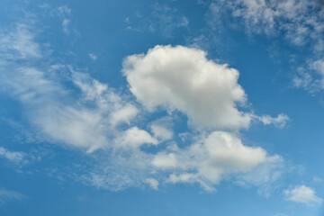Beautiful cumulus clouds against the blue daytime sky.
