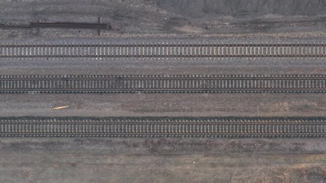 Railroad rails and sleepers, top view drone footage - Smooth Flight over empty railway tracks. Drone Flying Over Railway Tracks, Top View Panning Shot
