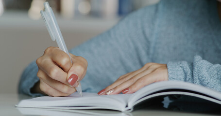 Woman write down the list on notebook at home