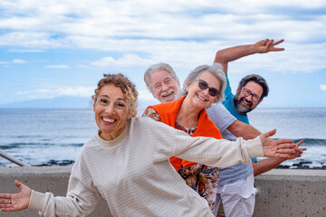 Playful group of family having fun together in outdoor excursion at sea, smiling carefree. Parents,...