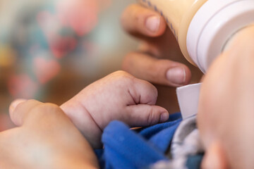 Close-up of a babys hand while it´s fed by it´s mother