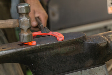 A farrier at work. A blacksmith preparing a horseshoe to apply it on a horse hoof. Horse shoeing...