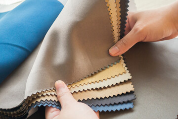 female designer with fabric color samples choosing textile for curtains