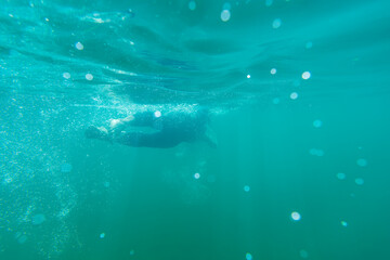 Fototapeta premium Athlete in a wetsuit swims in a lake