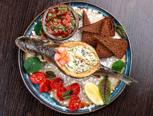 Seabass with spinach and cream sauce. On a wooden background