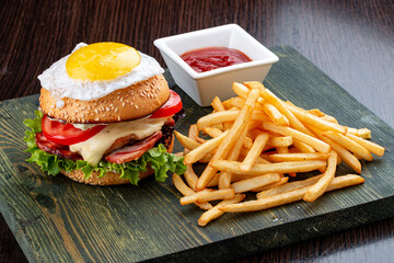 Burger for kids with fries and sauce. On a wooden background
