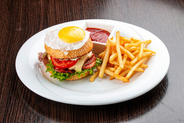 Burger for kids with fries and sauce. On a wooden background