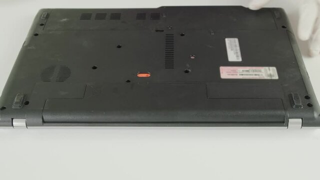 The wizard removes the battery from the laptop for repair. Laptop repair. Computer repair service