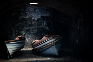Deux barques rangées dans une cave obscure