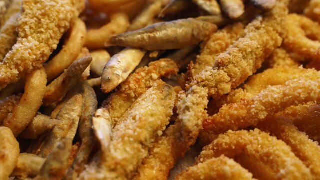 Served deep fried fish mix food set composition. Cook made squid rings, sprat, gobies, oysters on a tray in luxury asian restaurant. Delicious snacks and sauces in cafe.