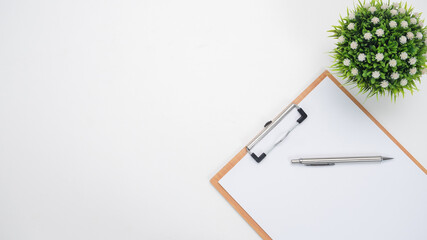 Pen on document board and vase on the table top view copy space white background