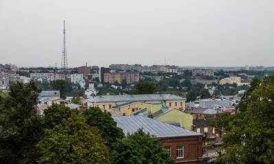 VLADIMIR, RUSSIA-AUGUST, 11, 2021: panoramic top view of the roofs of the historic buildings of the old city and the lush green foliage of trees on a cloudy summer day