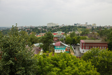 VLADIMIR, RUSSIA-AUGUST, 11, 2021: panoramic top view of the roofs of the historic buildings of the old city and the lush green foliage of trees on a cloudy summer day