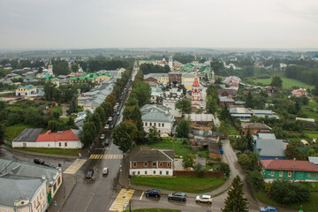 SUZDAL, Vladimir Region, RUSSIA-August, 11,2021: panoramic view of the old town with the roofs of historical buildings and the green foliage of trees on a cloudy summer day