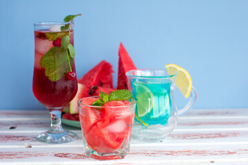 three types of different fruit and berry drinks. Cherry, watermelon red and blue with lemon alcoholic and non-alcoholic cocktails in summer
