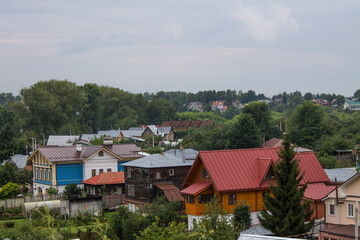 Fototapeta na wymiar panoramic top view of the old town with historical architecture among the green foliage of trees and a cloudy summer day in Suzdal Russia