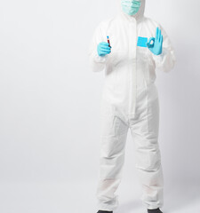 Man wear PPE suit and blue medical glove is holding blood test tube and do A ok hand sign on white background.