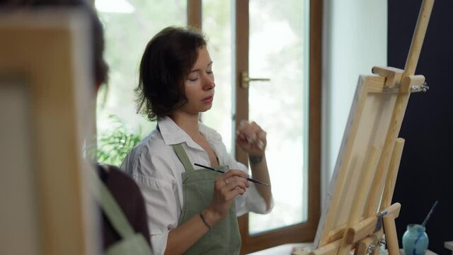 Female students painting at art lesson in art studio