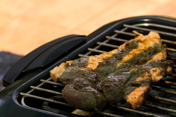 Grilling pork meat in a garden in summer