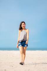 Portrait beautiful Asian woman walking at tropical beach and blue sky